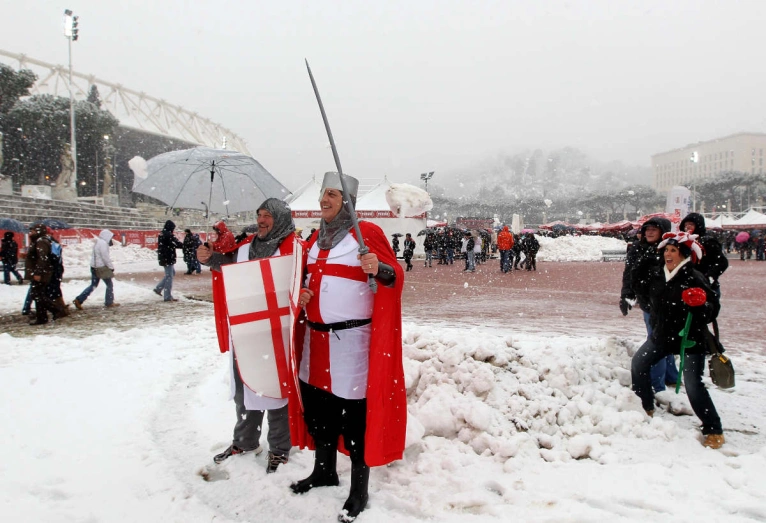 Dressed up England fans standing in snow