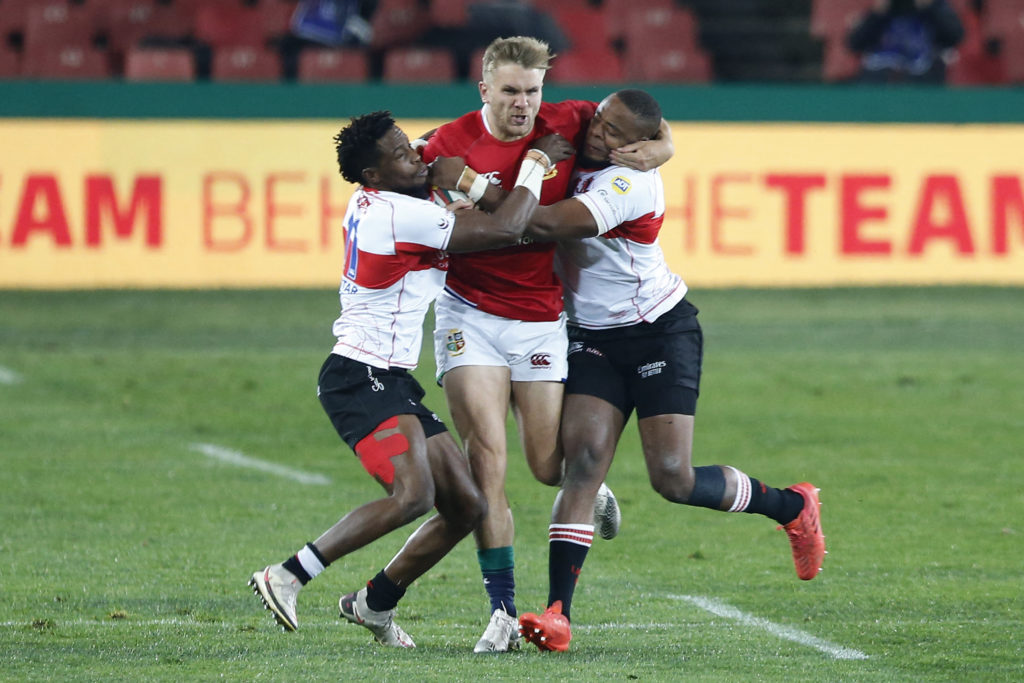 British and Irish Lions centre Chris Harris is tackled by two opponents